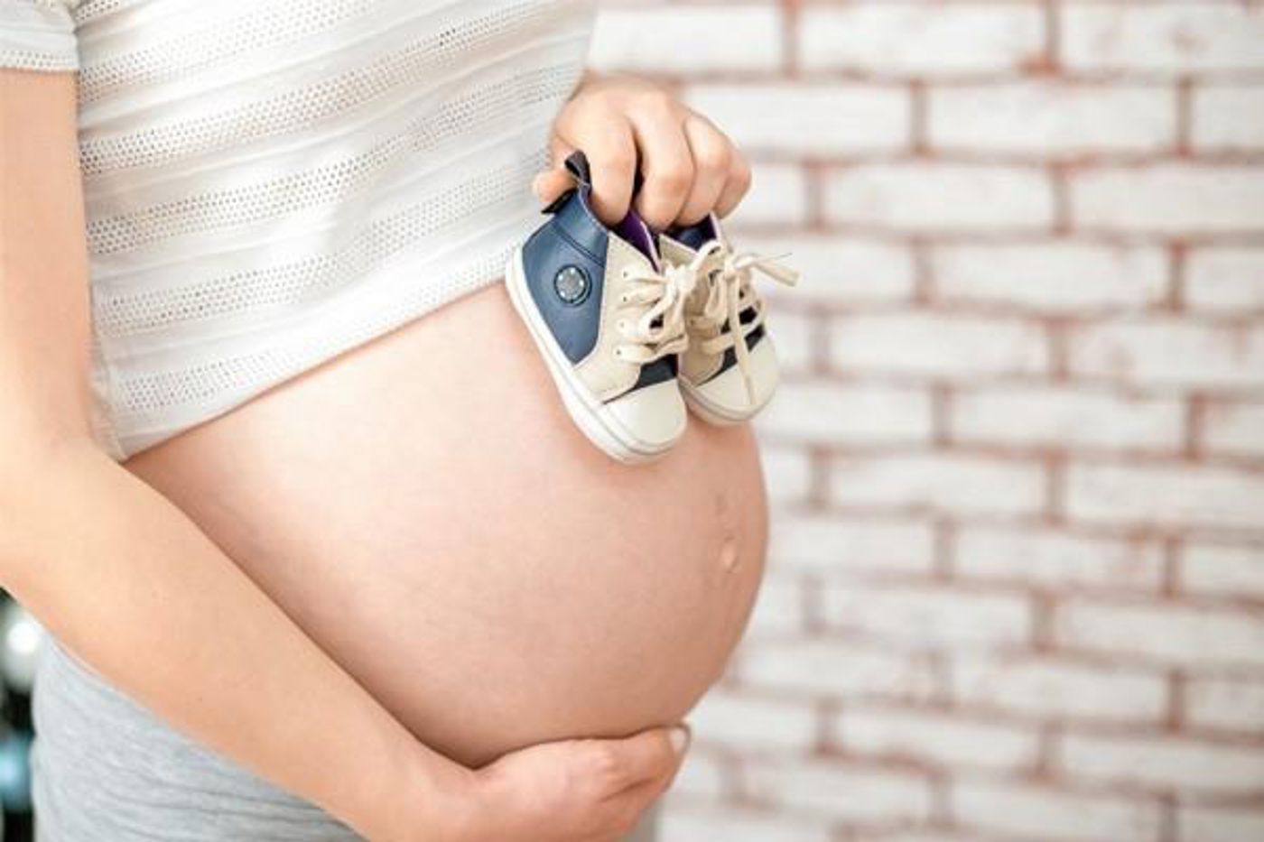 Baby schoenen op zwangere buik