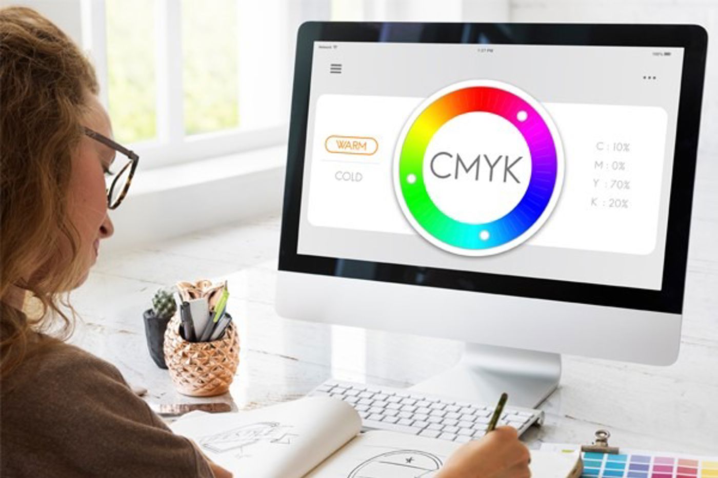 Persoon achter computer met kleurenpallet in beeld 